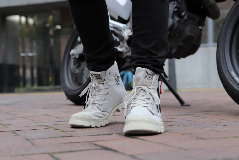 パラディウムの防水ブーツを着用したライダーの足元。アーバンライディングと街歩きを両立するデザイン。