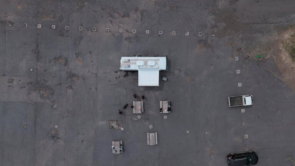 KUSHITANI EXPLORER PARKの食事エリアを上空から撮影した様子。キッチンカーとベンチが並ぶ